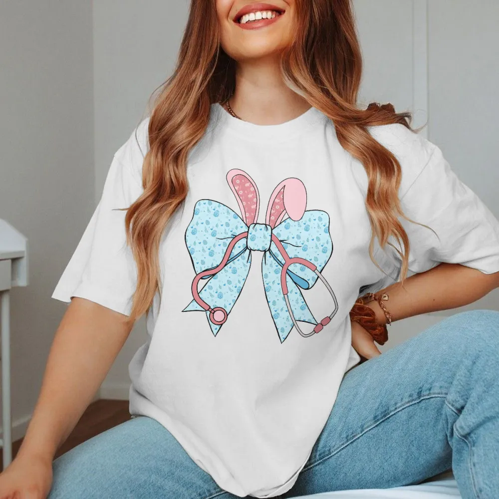 A Cartoon Rabbit Ear Element Bow Pattern, The Bow Has Blue Dots, The Rabbit Ears Are Pink With White Dots And A Pink Stethoscope Pattern, Casual T-Shirt