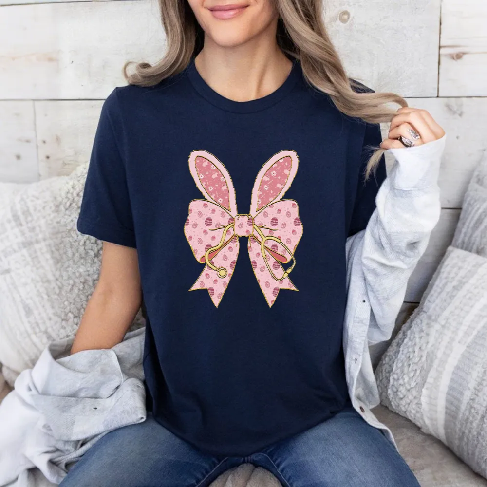 A Pink Bow Pattern With Bunny Ears And Pink Polka Dots, Hanging On A Golden Stethoscope And A Casual T-Shirt.