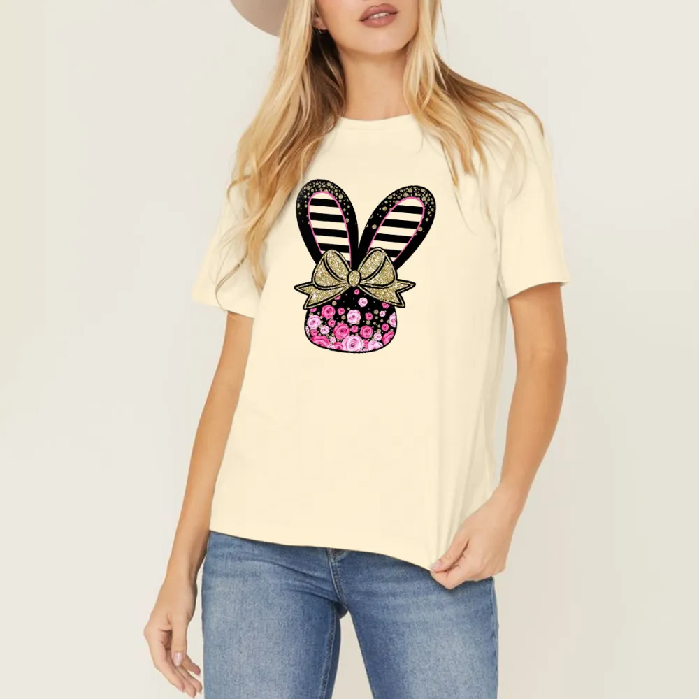 Cartoon Style Bunny Ears Pattern, The Ears Are Black And White Stripes, Tied With A Golden Bow With A Floral Pattern, And A Vase Covered With Pink Flowers, A Casual T-Shirt.