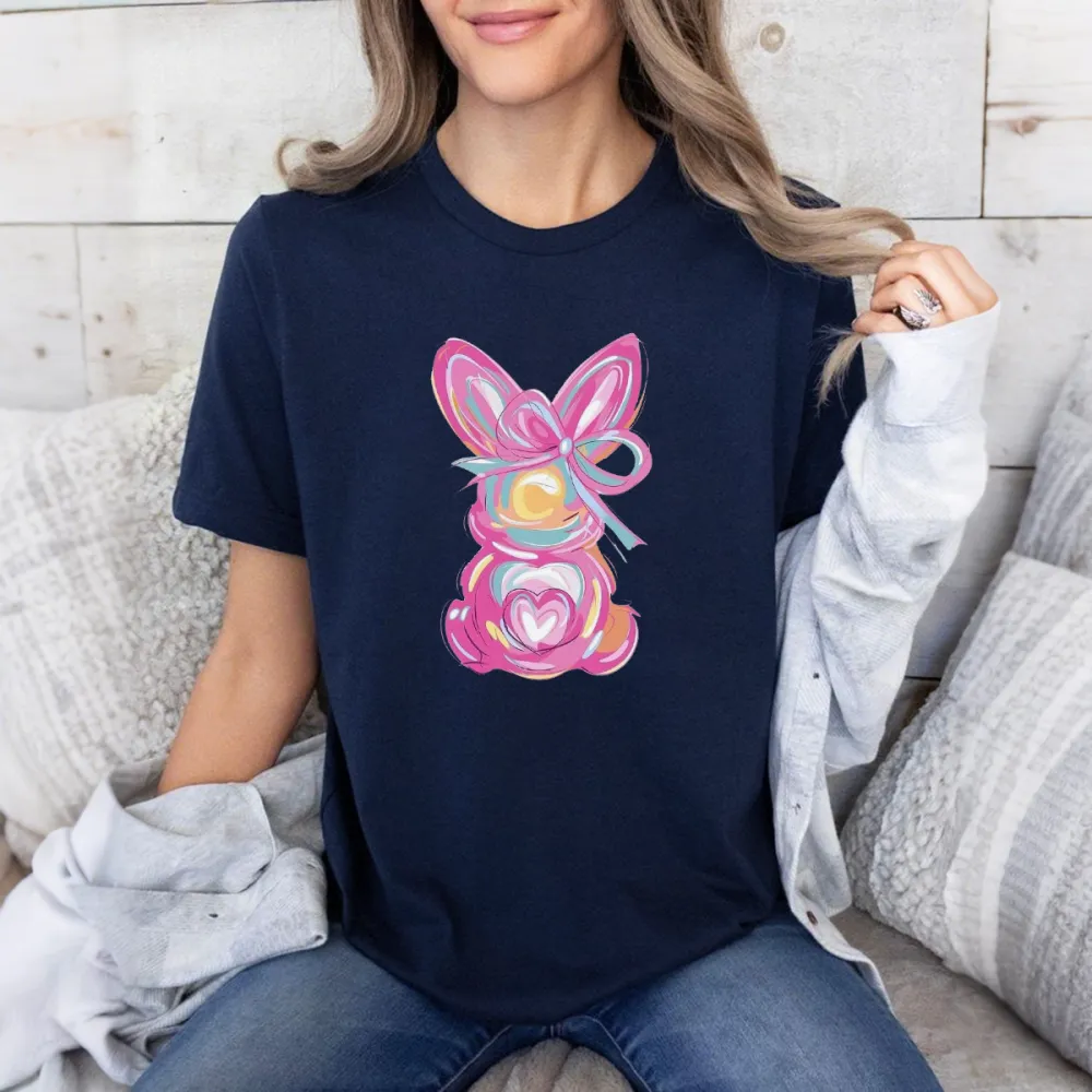 A Hand-Painted Rabbit Pattern With Pink As The Main Color, Matched With Blue, Yellow, Orange And Other Colors. The Rabbit Has Bow And Heart Elements On Its Body. It Is A Casual T-Shirt.