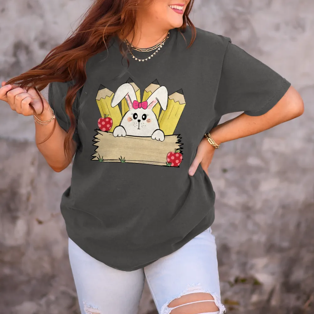 A Cartoon White Rabbit Wearing A Pink Bow Holding A Blank Board, A Yellow Pencil And A Red Strawberry With White Dots, A Childlike, Fresh Style, Casual T-Shirt
