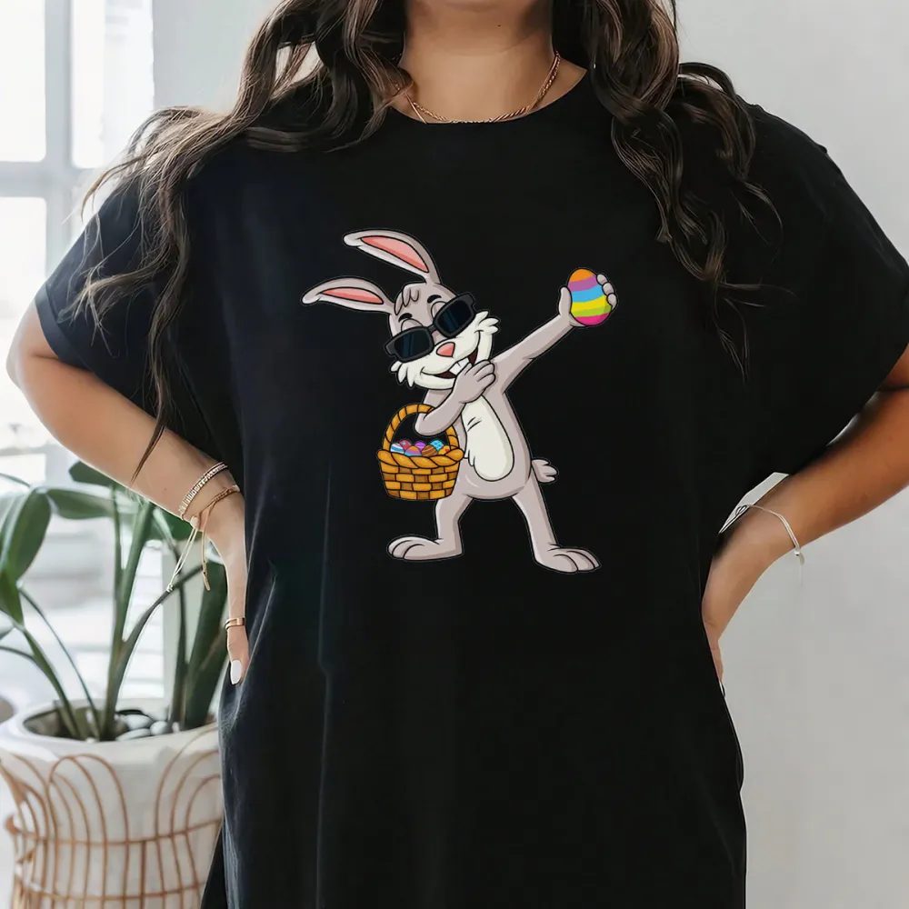 A Cartoon Rabbit Wearing Black Sunglasses, Holding A Colorful Easter Egg, With A Basket Full Of Eggs Next To The Other Hand. The Style Is Playful And Cute, With A Casual T-Shirt.