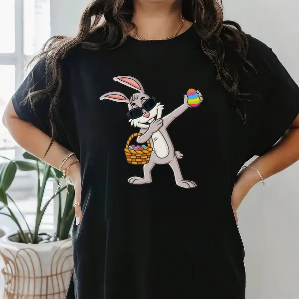 A Cartoon Rabbit Wearing Black Sunglasses, Holding A Colorful Easter Egg, With A Basket Full Of Eggs Next To The Other Hand. The Style Is Playful And Cute, With A Casual T-Shirt.