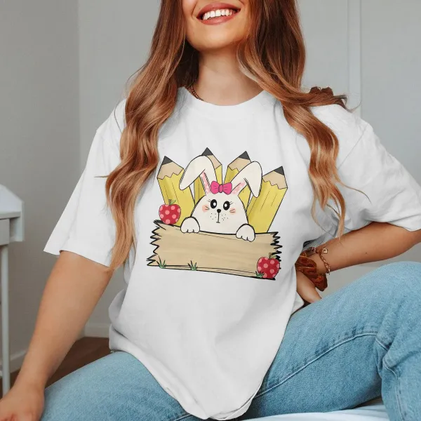 A Cartoon White Rabbit Wearing A Pink Bow Holding A Blank Board, A Yellow Pencil And A Red Strawberry With White Dots, A Childlike, Fresh Style, Casual T-Shirt