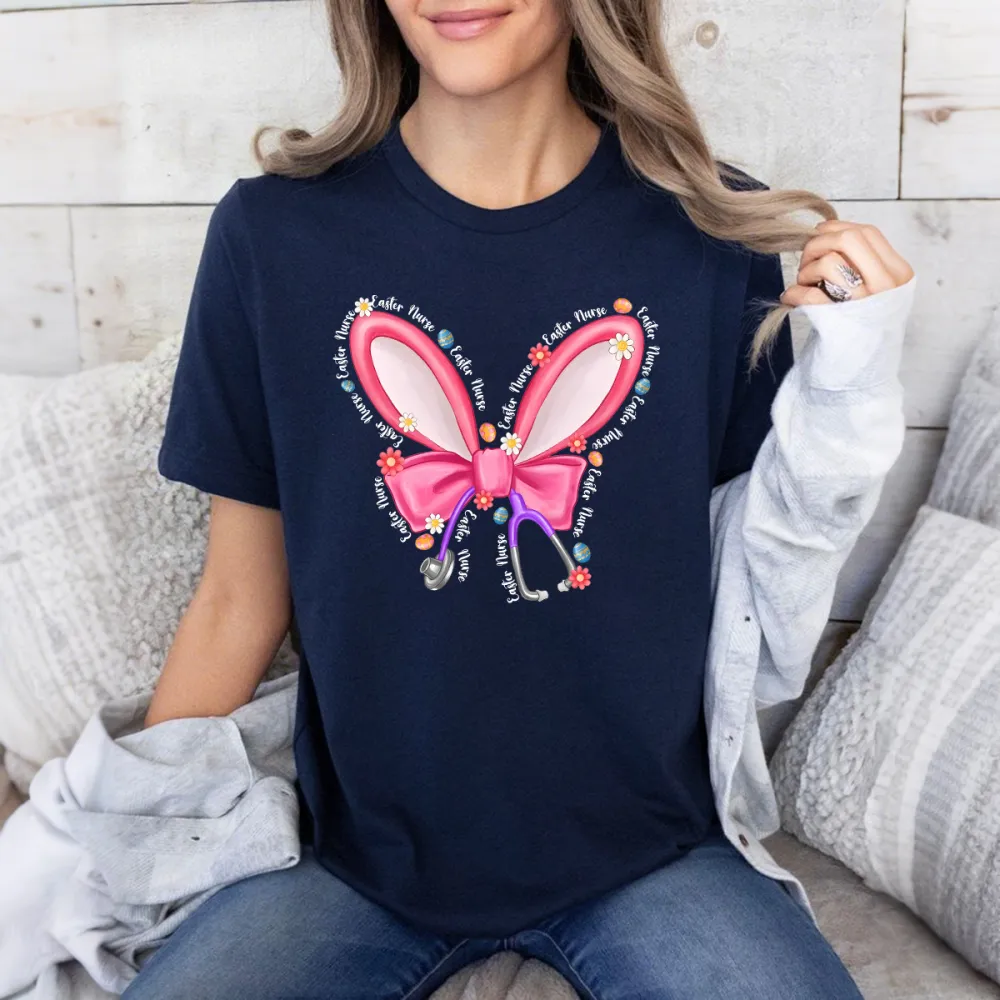 Repeating “Easter Nurse” Multiple Times, The Slogan Is Wrapped Around Pink Cartoon Bunny Ears And Bows, A Stethoscope, And Is Dotted With Small Flowers And Gems, And A Casual T-Shirt.