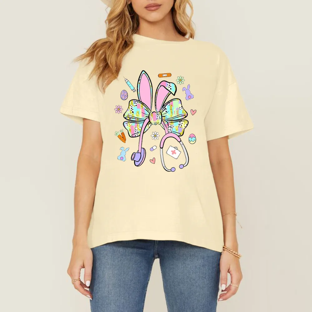 A Bow Pattern With Rabbit Ears, Patterns Of Various Colors On The Bow And Ears, Pencils, Rabbits, Small Flowers, Eggs, Stethoscopes, Heart Shapes, Full Of Childlike Fun, Casual T-Shirt