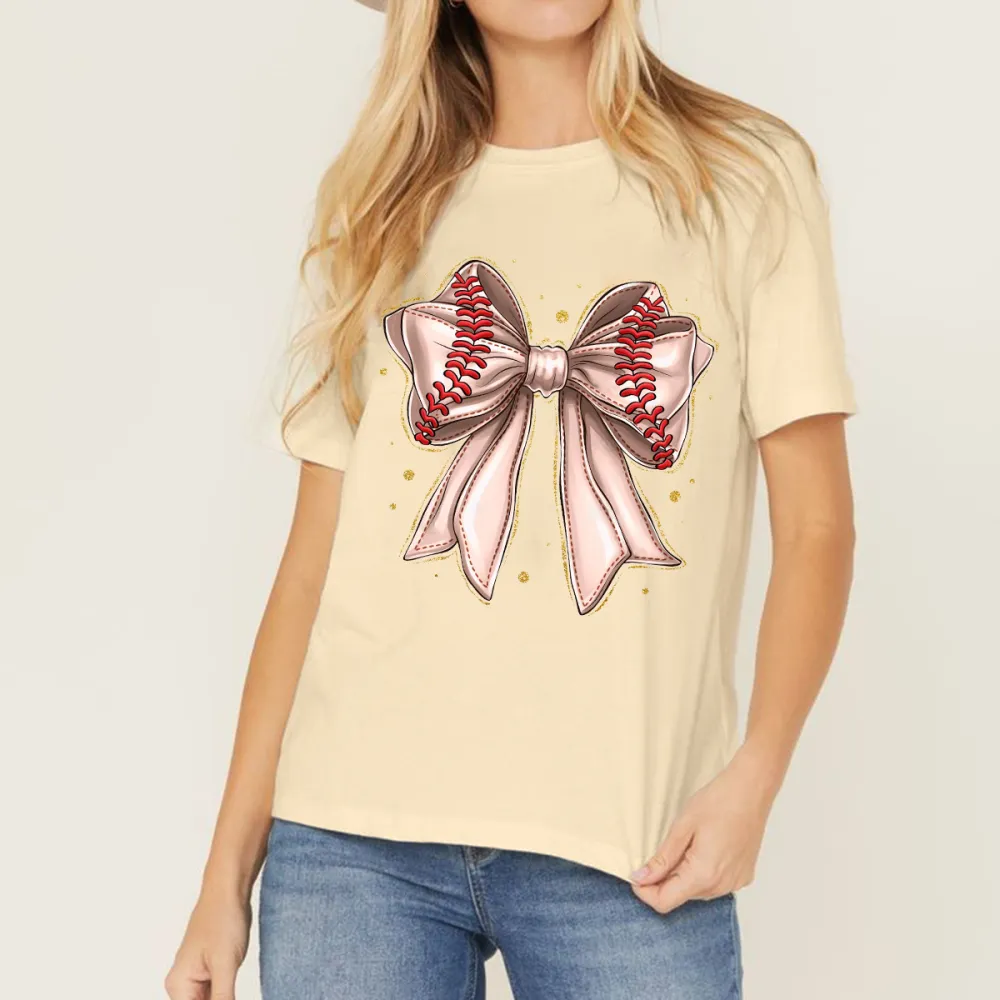 A Light Pink Bow Pattern With Red Baseball-Like Stitching Elements On The Edge Of The Bow And Some Gold Dots Around It, A Casual T-Shirt.