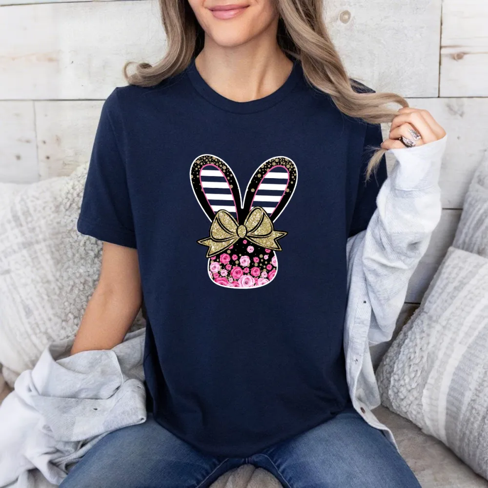 Cartoon Style Bunny Ears Pattern, The Ears Are Black And White Stripes, Tied With A Golden Bow With A Floral Pattern, And A Vase Covered With Pink Flowers, A Casual T-Shirt.