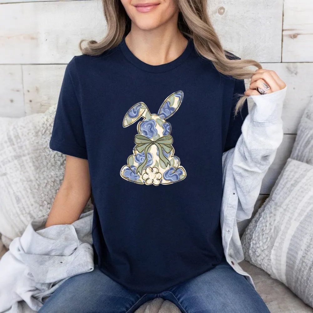 The Cartoon Rabbit Pattern Is Mainly Decorated With Blue And White Flowers And Tied With A Light Green Bow. The Style Is Fresh And Elegant, And It Is A Casual T-Shirt.
